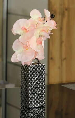 Pink flower in silver vase on glass table modern interiorの写真素材