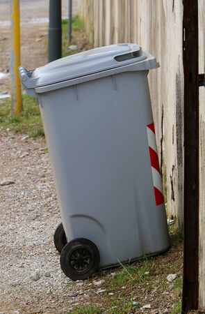 Plastic closed waste bin outside on streetの写真素材