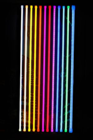 Colorful glowing light sticks on black wallの写真素材
