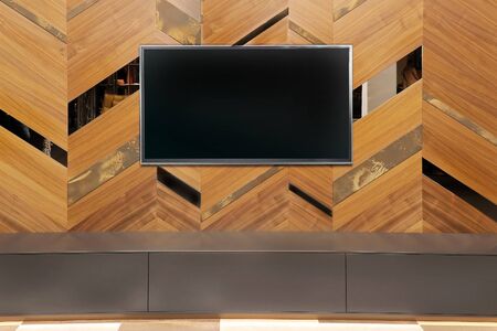 Large television with black screen on decorative wooden wall interior