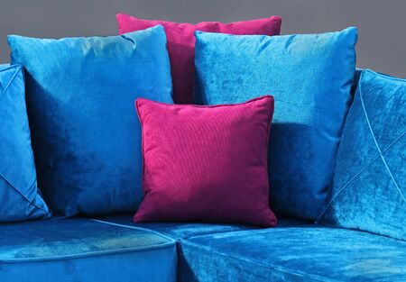 Decorative purple velvet material pillow on blue textile couch furnitureの写真素材