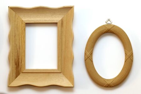 Two retro brown wooden frames hanging on white wall interiorの写真素材