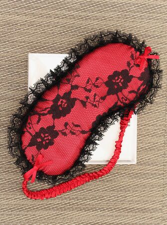 Fashionable red lace sleep mask with black decorative detailsの写真素材