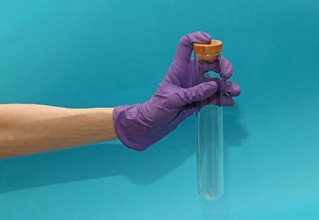 Female hand with medical glove holding empty test tubeの写真素材