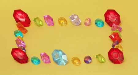 Colorful diamond stones arranged in square on yellow backgroundの写真素材