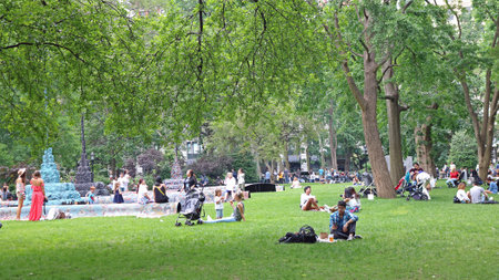 New York, USA - June 05, 2019: People enjoying nice weather on the loan of Central park in New York city. People having nice time with their children, family and friends in nature.のeditorial素材