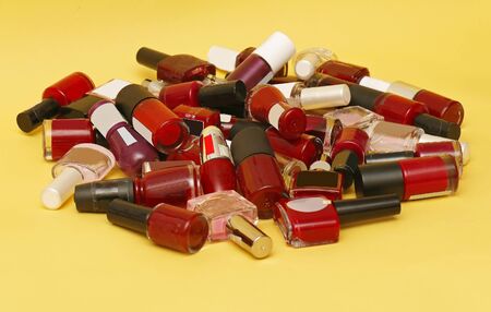Large pile of nail polishes glass containers predominantly in red color shadesの写真素材