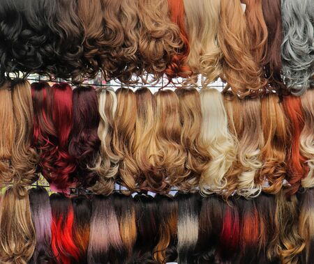 Colorful real and fake hair wigs sold on outside marketの写真素材