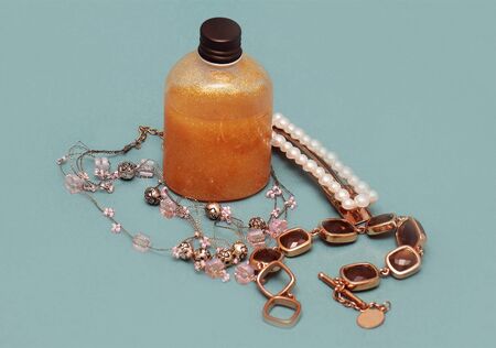 Gold skin gel inside glass bottle and jewelry aroundの写真素材