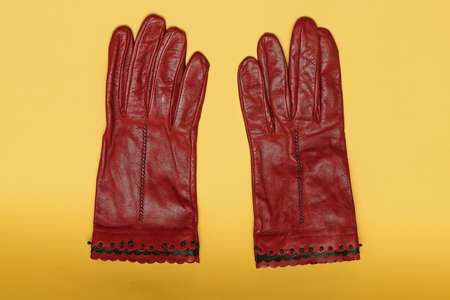 Stylish fashionable red leather gloves on yellow backgroundの写真素材