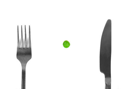 Small meal of one pea and silver cutlery as eating disorder conceptの写真素材
