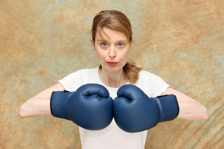 Young attractive female boxer ready to fight in sport equipment