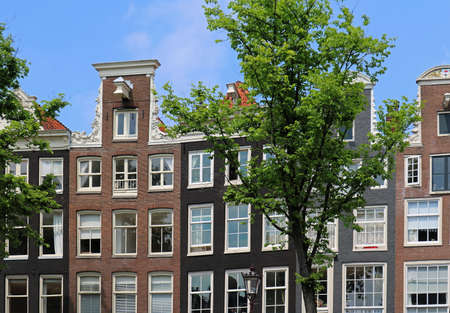 Old urban house facade with many windows in Amsterdamの写真素材