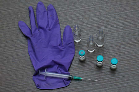 Vaccine vials with needle injection and medical gloveの写真素材