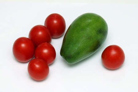 Fresh organic small red tomatoes and avocado on white backgroundの写真素材