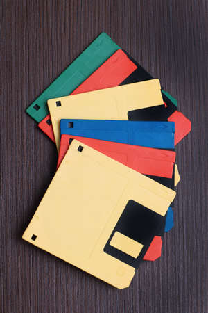 Retro colorful floppy disks stack on wooden table backgroundの写真素材