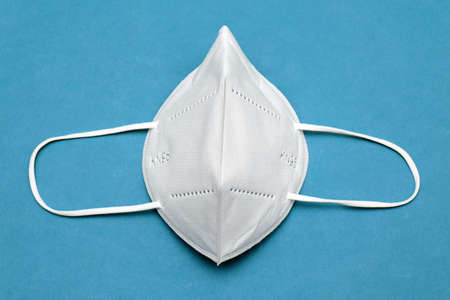 Medical KN95 face mask for protection against virus on blue backgroundの写真素材