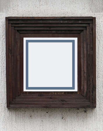 Old brown wooden square frame on facade wall