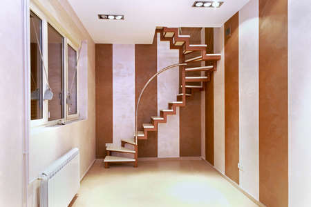 Spiral stairs inside corner of small modern room interiorの写真素材