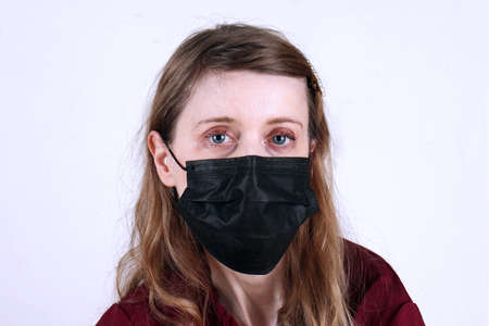 Pale complexion goth style young teenage girl wearing black disposable mask for virus protectionの写真素材