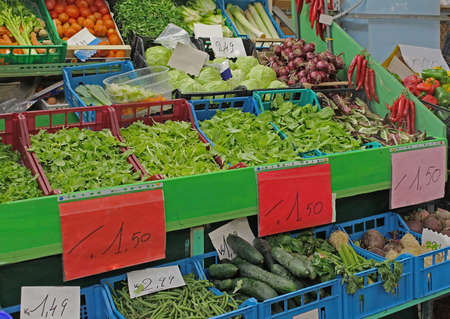 Colorful fresh organic raw vegetables in plastic crates on small marketの写真素材