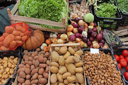 Potatoes and other organic raw vegetables in crates sold on market stallの写真素材