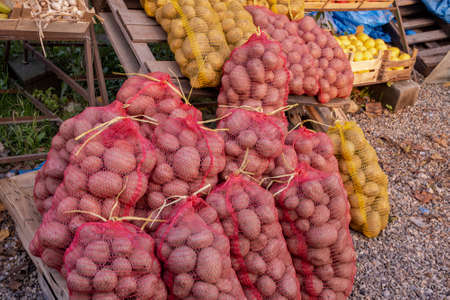 Raw organic potatoes in sacks sold on outdoors marketの写真素材