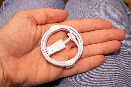 Folded connection data USB to lightning cable in mens hand