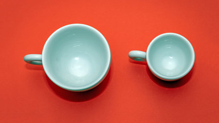 White empty ceramic cups for espresso coffee isolated on red backgroundの写真素材