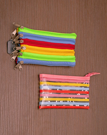 Closed decorative pencil boxes pouches on wooden background used by school childrenの写真素材