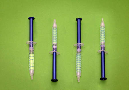 Full plastic syringes for medical procedures on green backgroundの写真素材