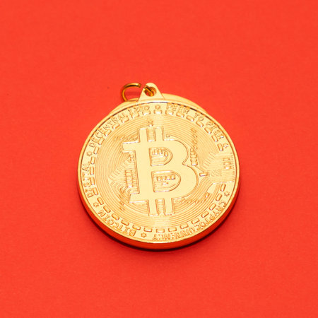 Gold bitcoin detail isolated on red backgroundの写真素材