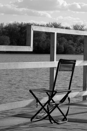 chair on deck by waterの写真素材