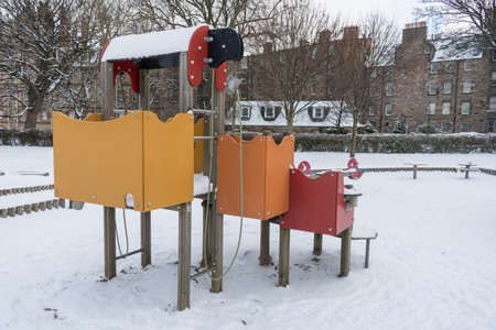Empty, frozen children playground covered by snow at Meadows Park in Edinburgh, United Kingdomの写真素材