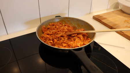 cooking pasta in a pan on the stove in the home kitchenの写真素材