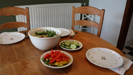 vegetable salad in a bowl on the wooden table with chairsの写真素材