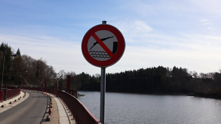 No swimming sign on a bridge over a lake in winter time.の写真素材