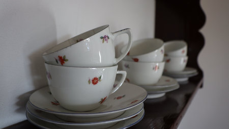 Coffee cups and saucers on a shelf in a cafeの写真素材