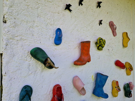 Colorful rubber boots on the wall of a shop in the village