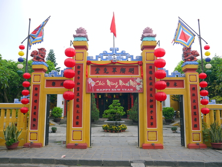 HOI AN, VIETNAM - 17TH MARCH 2018: The gate of the traditional land God temple with happy new year sign and colorful flags in Hoi An, Vietnamのeditorial素材