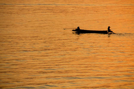 Fisherman on a small boat in the lake.の写真素材
