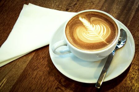 Hot coffee in the white ceramic cup on the wood table.の写真素材