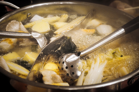 Cooking food by put a meat and vegetable in to a hot pot for make a shabu.の写真素材