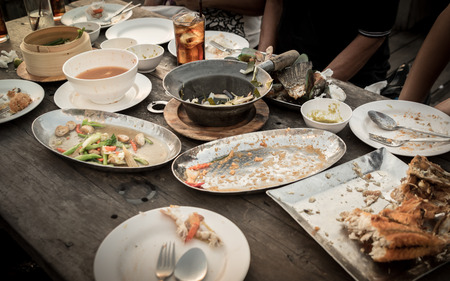 Dirty dish with food scraps on a tableの写真素材