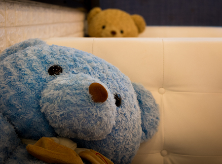 Blue bear doll on a white sofaの写真素材