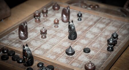 Two man playing thai chess on the wooden board.