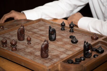 Two man playing thai chess on the wooden board.の写真素材