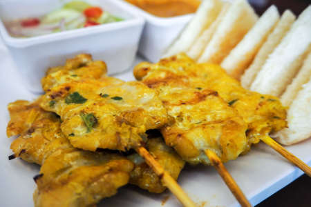 Thai appetizer pork satay with bread and peanut sauce.の写真素材