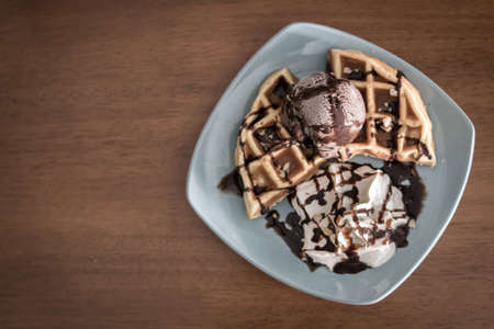 Close up of chocolate ice cream with a waffle on a plateの写真素材
