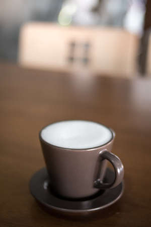 Hot coffee in the ceramic cup on the table.